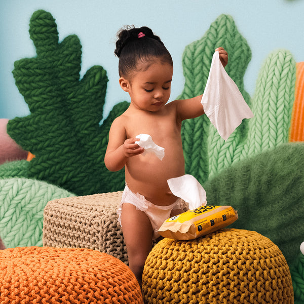 Child playing with wipes in a colorful, knitted setting