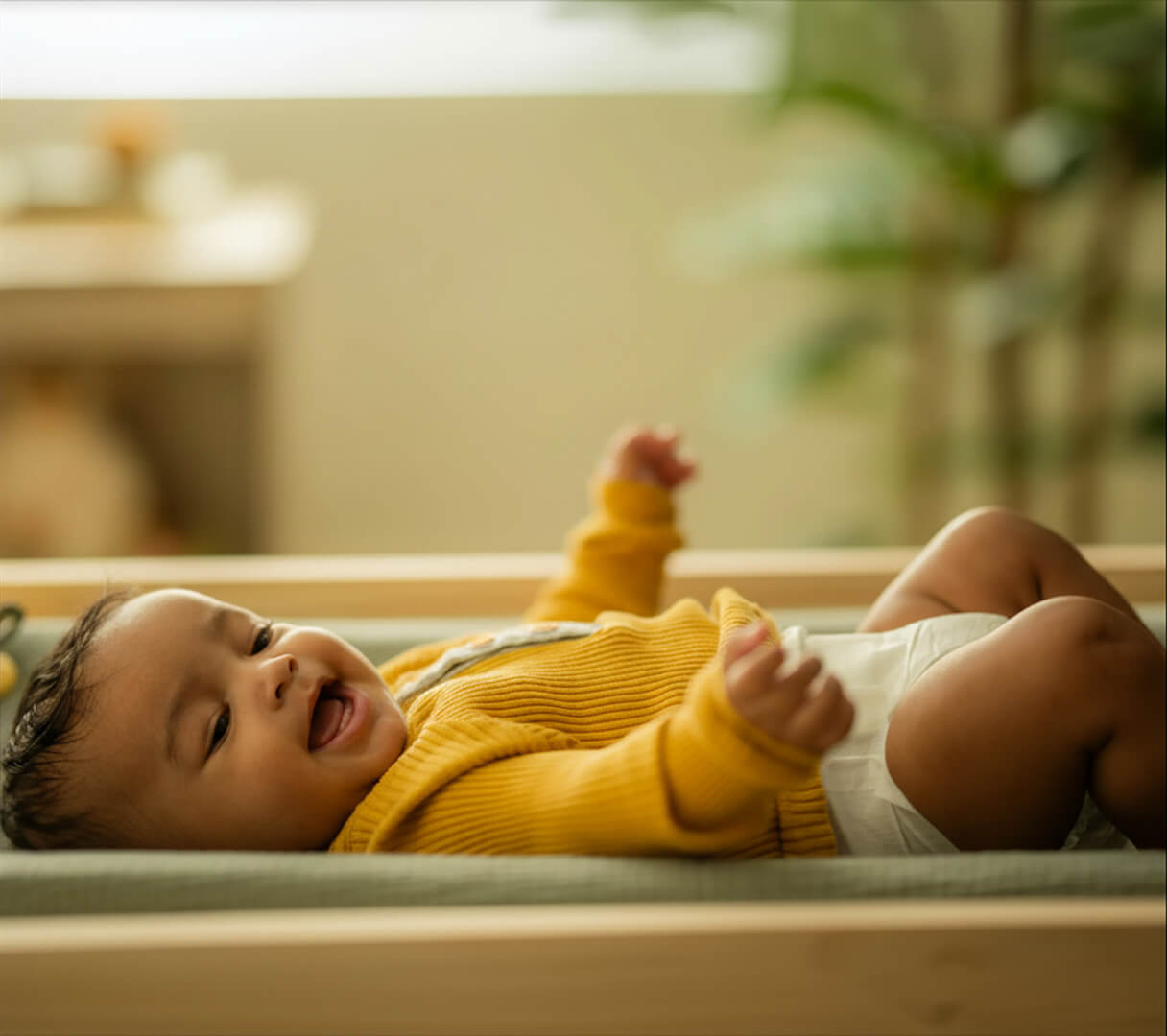 A baby lying down smiling in a Dyper diaper