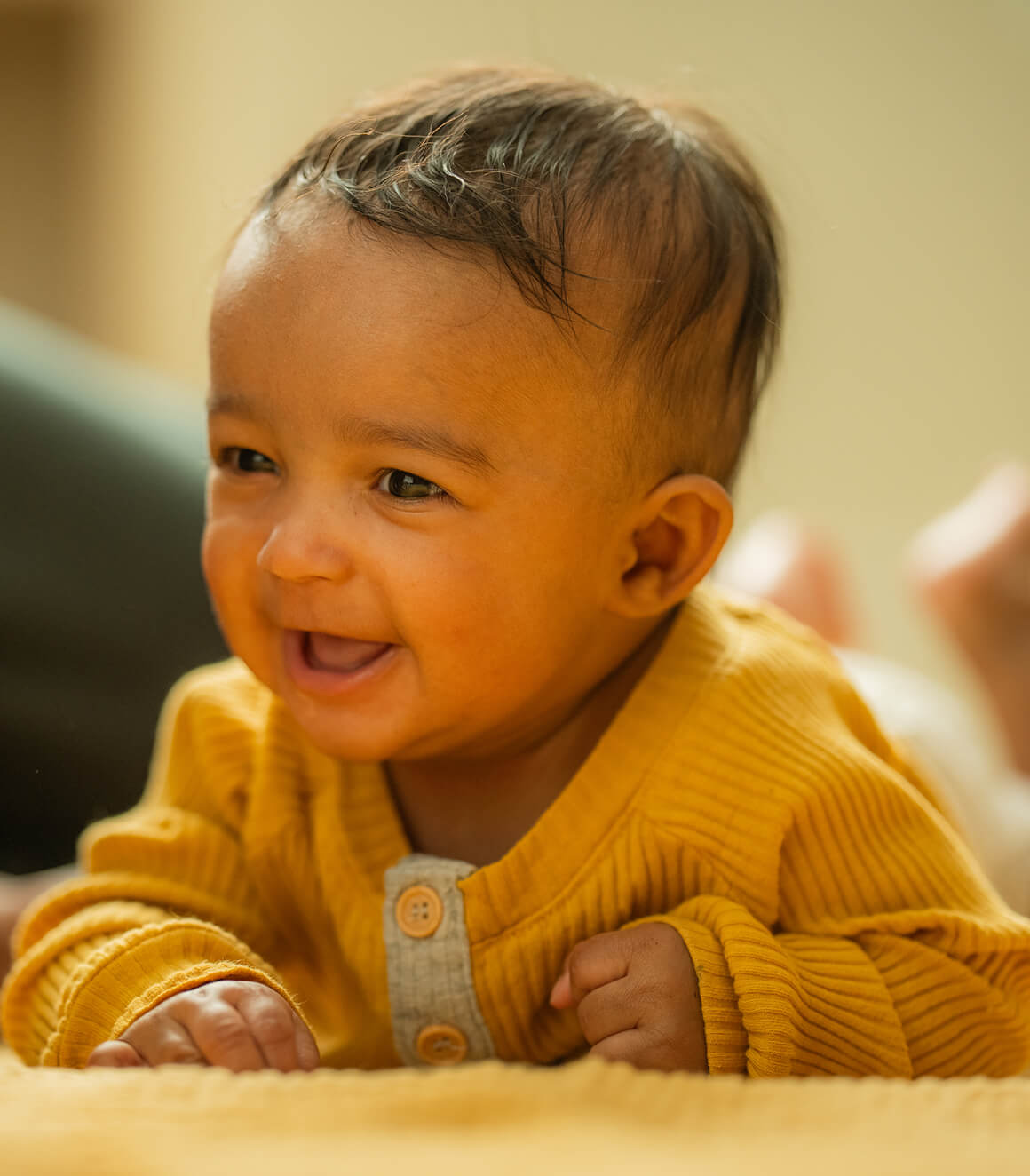 Smiling baby in a yellow outfit